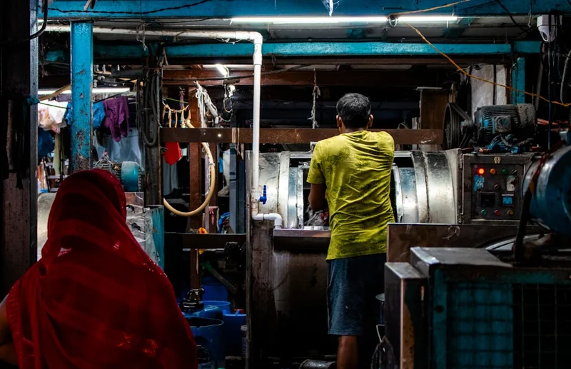 Trabajador en una lavanderia industrial cargando ropa